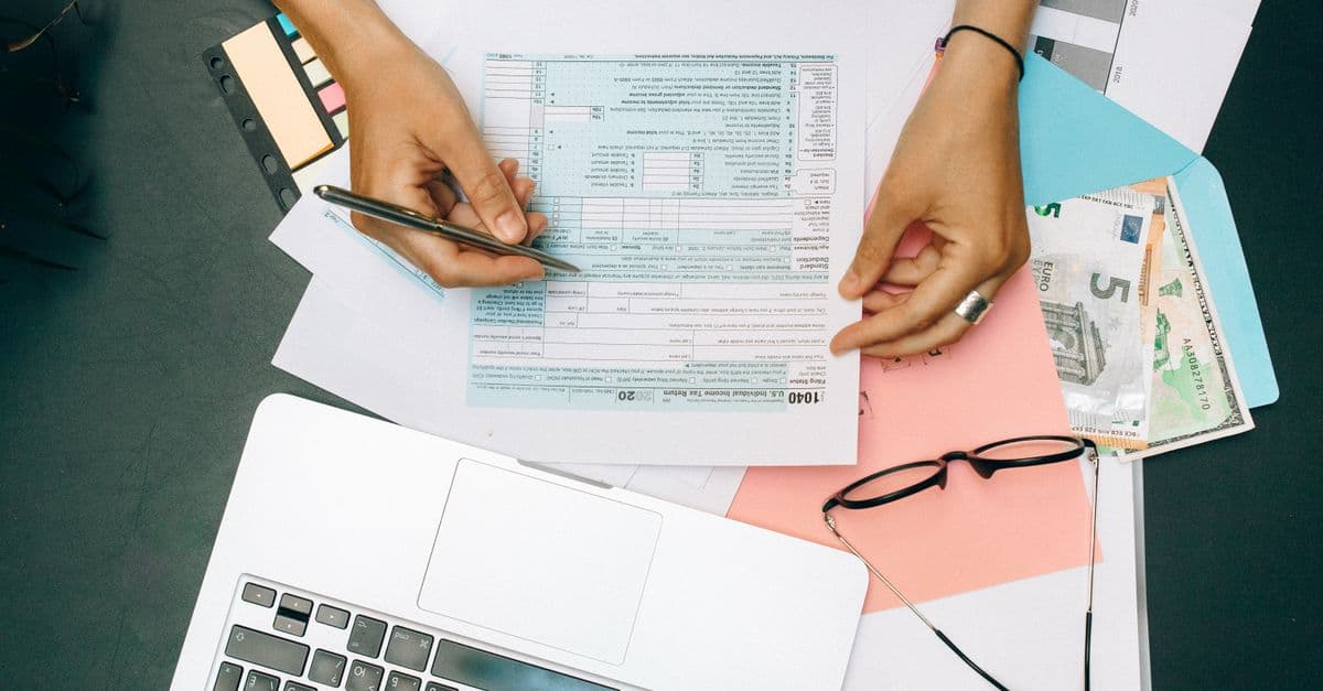 An accountant reviewing lease documents on a laptop at a desk