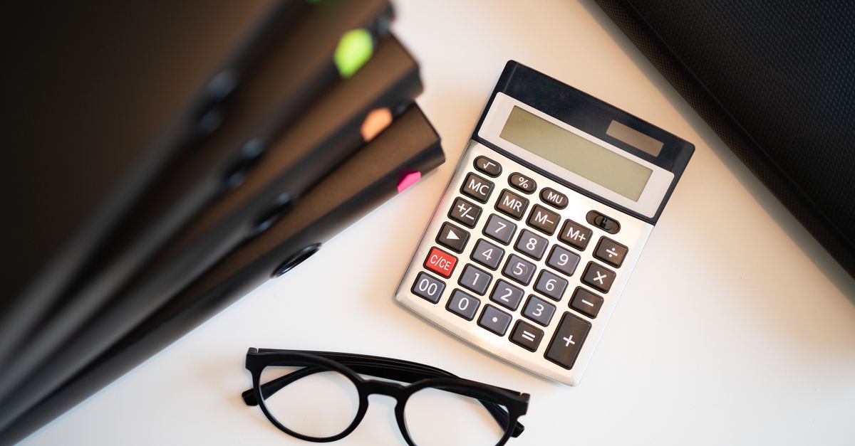 A calculator, glasses and folders on an office desk used to work out a lease liability