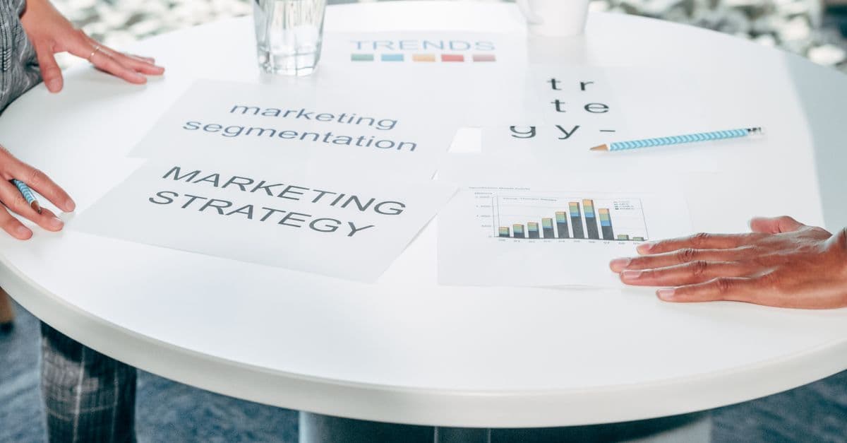 Two professionals comparing strategy documents at a table